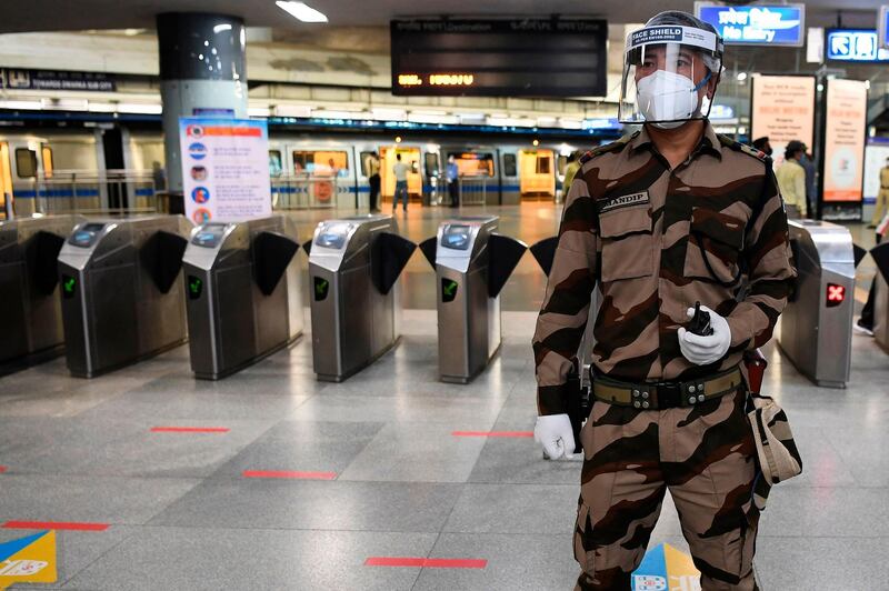 A Central Industrial Security Force personnel wearing PPE stands guard during a media preview as the Delhi Metro network prepares to resume services partially, at Rajeev Chowk metro station in New Delhi.  AFP