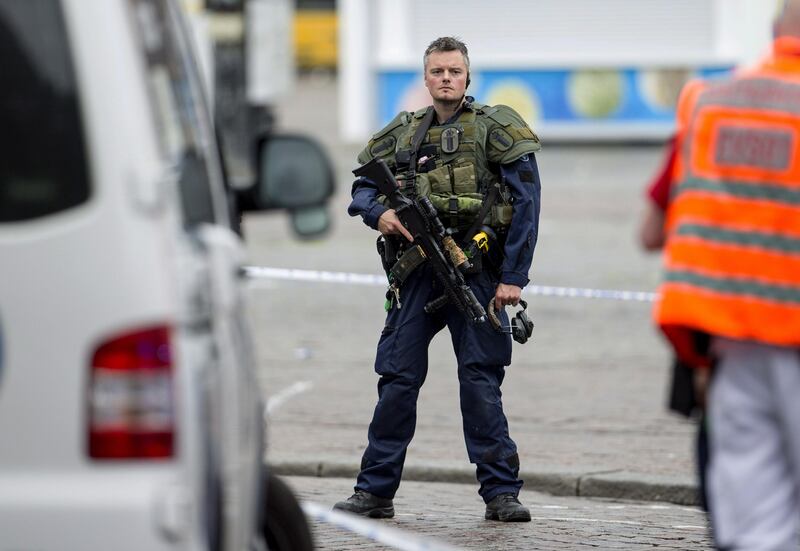 An armed police officer secures the area following a multiple stabbing attack on the Market Square in Turku, Finland.  Roni Lehti / Lehtikuva via AP.