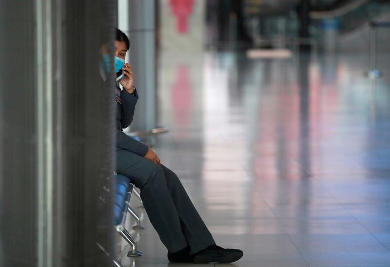 A staff wearing a protective face mask uses her phone at Suvarnabhumi Airport as the government extends a ban on incoming passenger flights until the end of April, following the coronavirus disease (COVID-19) outbreak, in Bangkok, Thailand April 16, 2020. REUTERS/Soe Zeya Tun