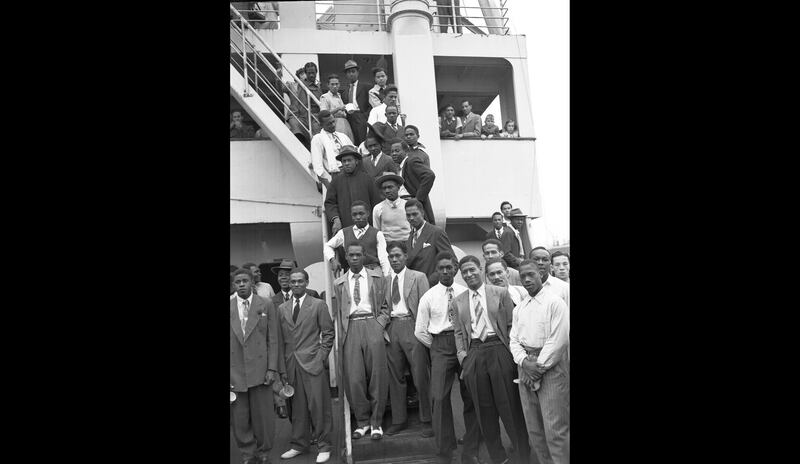 In this June 22, 1948 file photo, Jamaican men, mostly ex-Royal Air Force servicemen, pose for a photo aboard the former troopship, S.S. Empire Windrush, before disembarking at Tilbury Docks, England. June 22, 2020 marked the 72nd anniversary since the Empire Windrush ship brought hundreds of Caribbean immigrants to a Britain seeking nurses, railway workers and others to help it rebuild after the devastation of the Second World War. Eddie Worth / AP