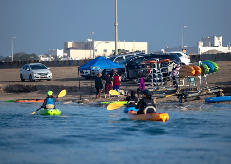 Parents head out in kayaks while their children take part in their sailing lesson.
