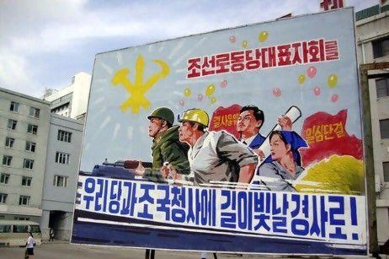 A large campaign poster is posted in a street, promoting a Workers' Party conference.