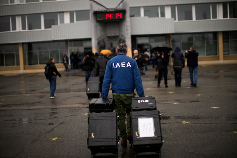 Members of a team from the International Atomic Energy Agency carry equipment as they arrive at the Chernobyl nuclear power plant, in Chernobyl, Ukraine. AP