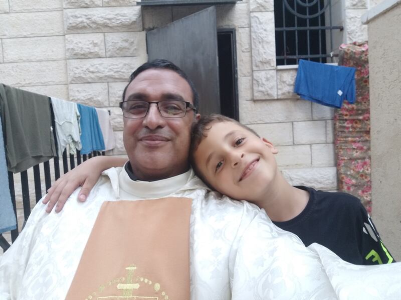 Father Youssef Asaad, a priest at the Church of the Holy Family, in Gaza with one of the more than 100 Palestinian children sheltering in the church grounds in northern Gaza