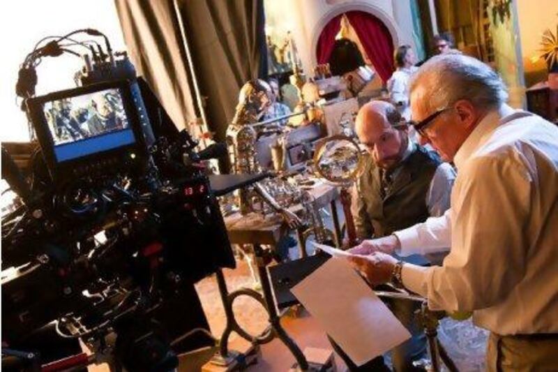 Ben Kingsley (center right, as Georges Melies) confers with director/producer Martin Scorsese (far right) on the set of Hugo.