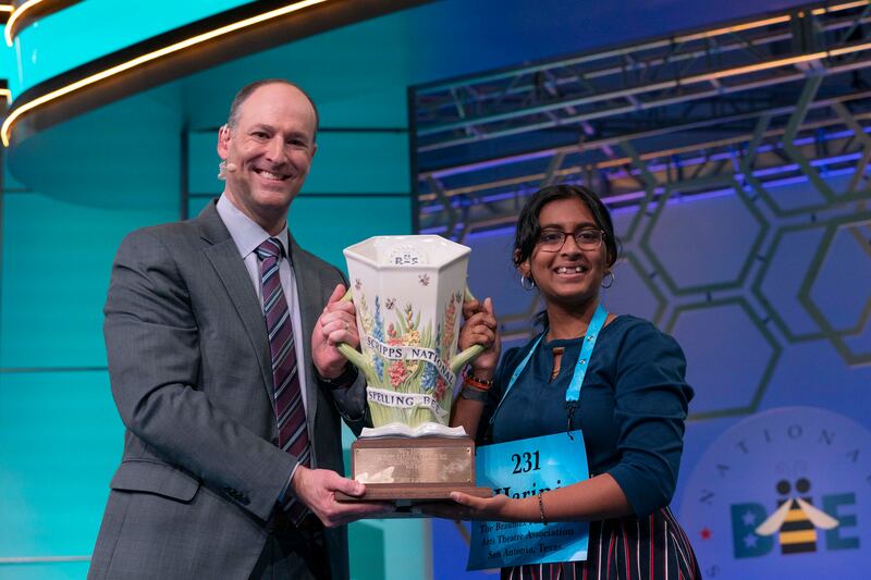 Harini Logan, 14, from San Antonio, Texas, and  President and CEO of Scripps Company Adam Symson, hold the  Scripps National Spelling Bee winning trophy. AP