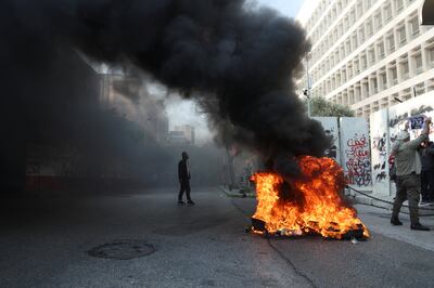 Demonstrators stand near burning tyres during a protest organised by Depositors' Outcry outside Lebanon's central bank in Beirut last month. Reuters