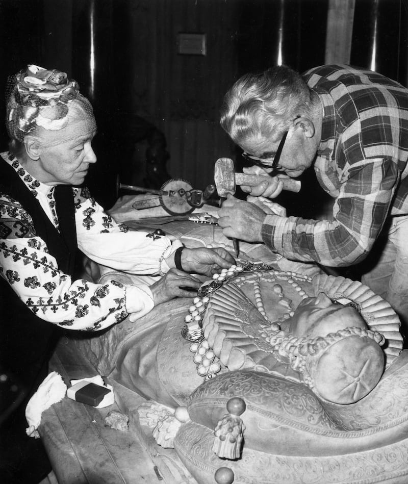 Jewellery maker Mrs Hughs of Cambridge restoring the gilded collar and pendant on the effigy of Queen Elizabeth I on her tomb at Westminster Abbey in 1975