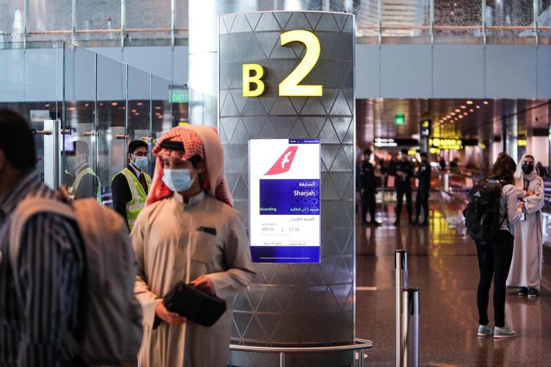 Mask-clad travellers wait at the gate before boarding the first flight to Sharjah after the resumption of air travel between Qatar and the United Arab Emirates, at Qatar's Hamad International Airport on January 18, 2021. AFP