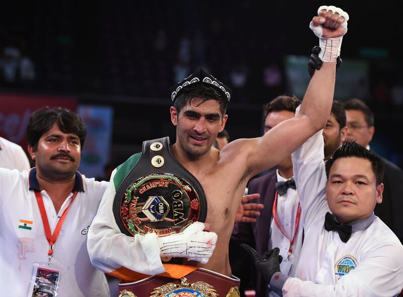Indian boxer and WBO Asia-Pacific Super Middleweight champion Vijender Singh (C) celebrates after winning the double title bout against China's Zulpikar Maimaitiali at the National Sports Complex of India (NSCI) Dome in Mumbai on August 5, 2017. / AFP PHOTO / PUNIT PARANJPE