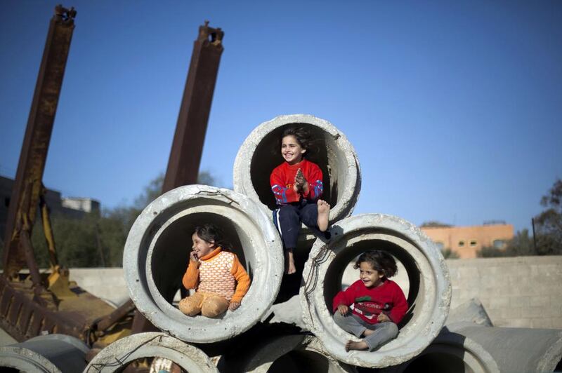 Palestinian children play with concrete pipes in Gaza City, on January 28, 2014. Mohammed Abed / AFP photo