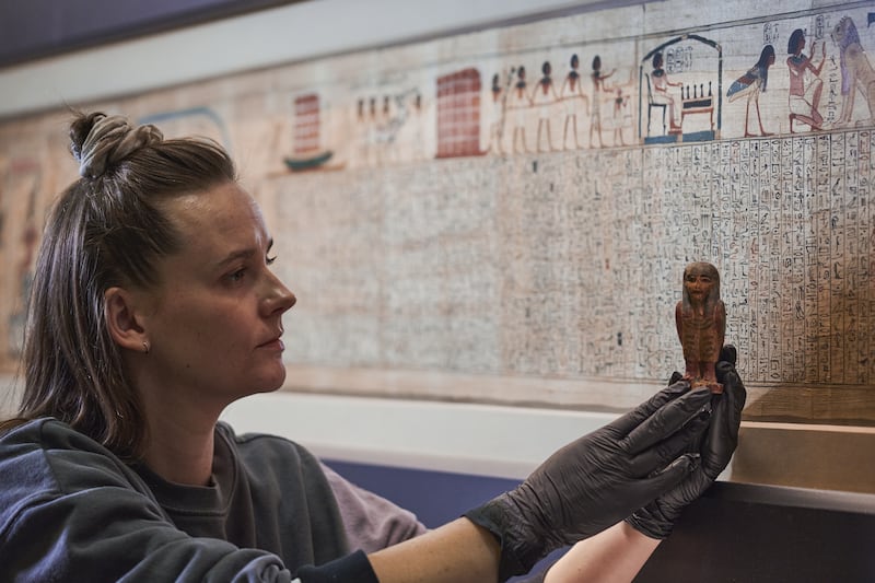 Installation of an amulet in front of The Book of the Dead. Photo: The Trustees of the British Museum