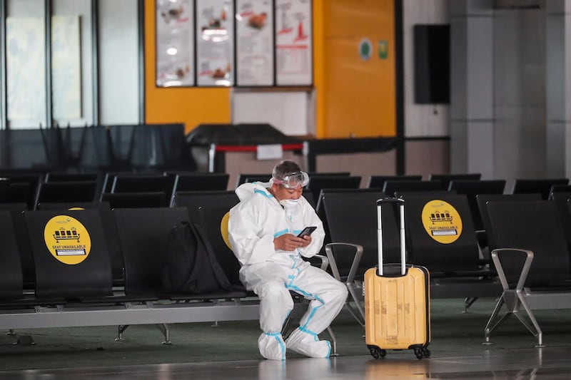 A passenger waits for their flight schedule at an almost empty departure lounge, at Soekarno-Hatta International Airport in Tangerang, Indonesia. The Indonesian government has banned commercial air travel from April 24 to June 1, in an effort to prevent people from returning to their hometowns to celebrate Eid al Fitr, which marks the end of Ramadan. EPA