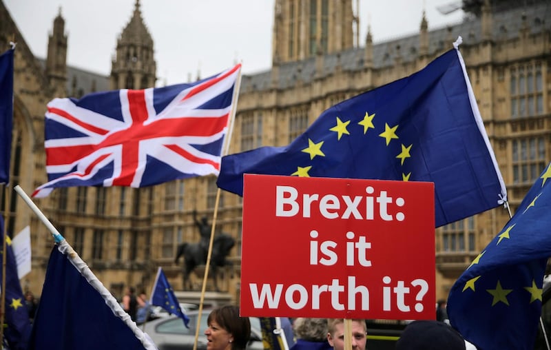 (FILES) In this file photo taken on June 12, 2018, pro-EU demonstrators hold placards and wave flags during an anti-Brexit protest outside the Houses of Parliament in London. In the shadow of London's Big Ben, members of parliament weary of the endless commotion over Brexit head into a chimney-stacked building to meditate and recharge inside polished offices. The stressed out MPs do not fold themselves into the lotus position on yoga mats but instead sit at desks and breathe. / AFP / Daniel LEAL-OLIVAS

