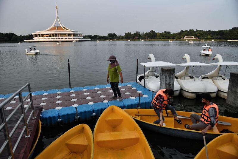 A couple wearing face masks prepare to go rowing in a lake in the King Rama IX public park in Bangkok, Thailand. AFP