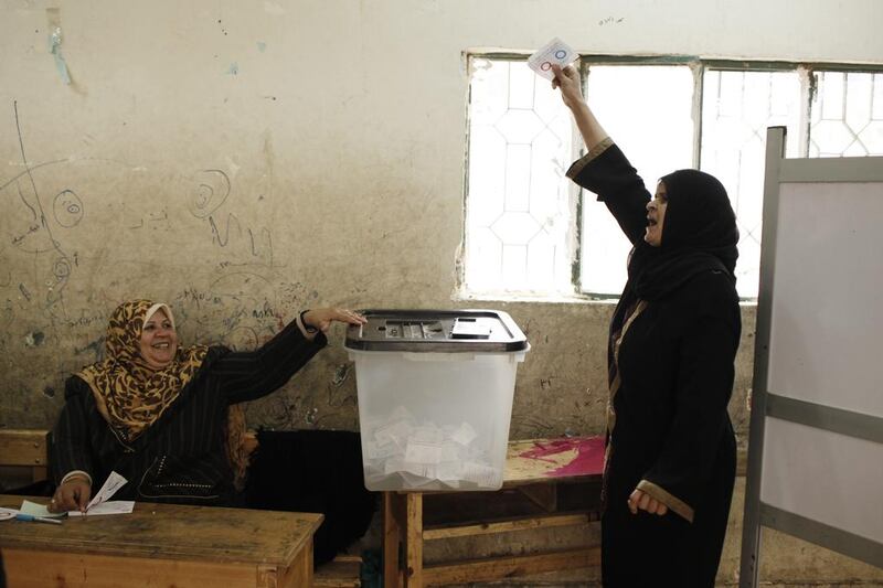 A woman places holds up her ballot before voting on Tuesday in Egypt's referendum on a new constitution. Ed Giles/Getty Images