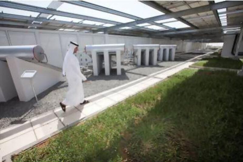 A Dewa employee walks near the solar water heater and the green roof system at Dewa’s new Sustainable Building in Al Quoz. Jaime Puebla / The National