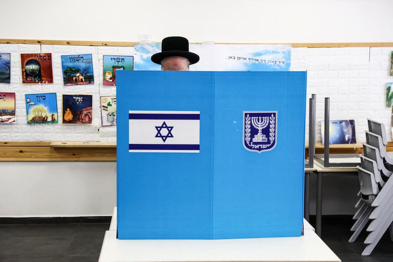 An Ultra-Orthodox Jewish Israeli selects his ballot paper on the day of Israel's general election at a polling station in Jerusalem. Reuters
