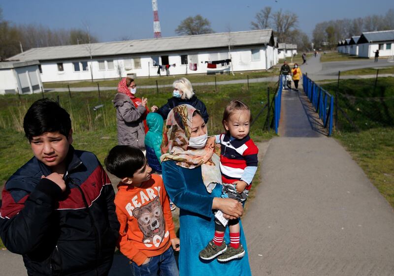 Migrants wait in garden during the vaccination in the Krnjaca refugee centre near Belgrade, Serbia. AP Photo