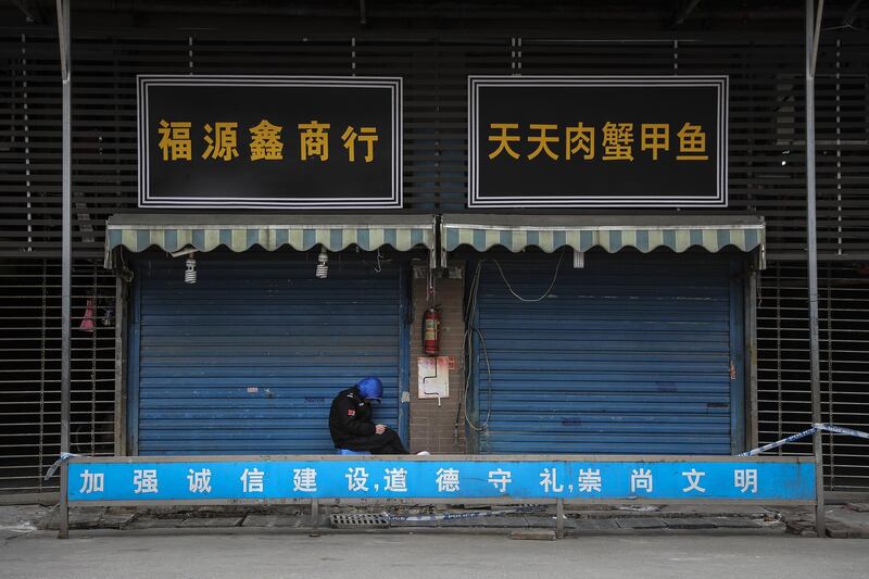 A security guard sits outside the closed Huanan market in Wuhan, Hubei province. Getty Images

