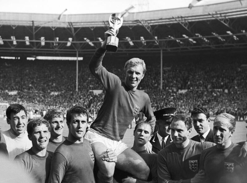 Bobby Charlton, far right, looks on as Bobby Moore lifts up the Jules Rimet trophy after England's 1966 World Cup final triumph at Wembley. AP