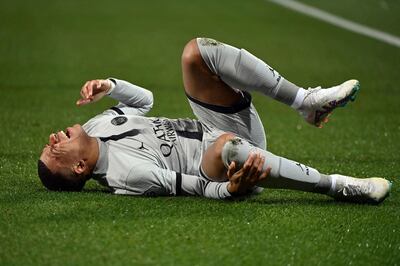Paris Saint-Germain's French forward Kylian Mbappe lies on the ground after getting injured. AFP