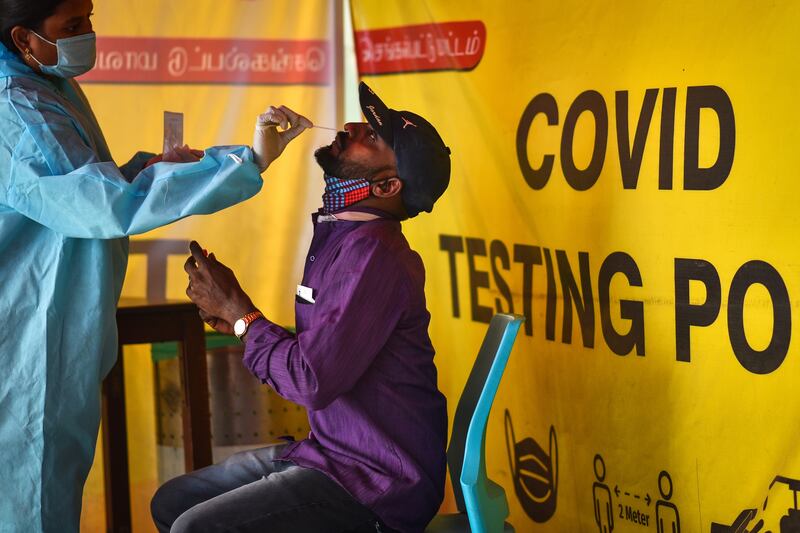 A health worker collects a sample from a passenger arriving on an international flight at Chennai international airport. EPA