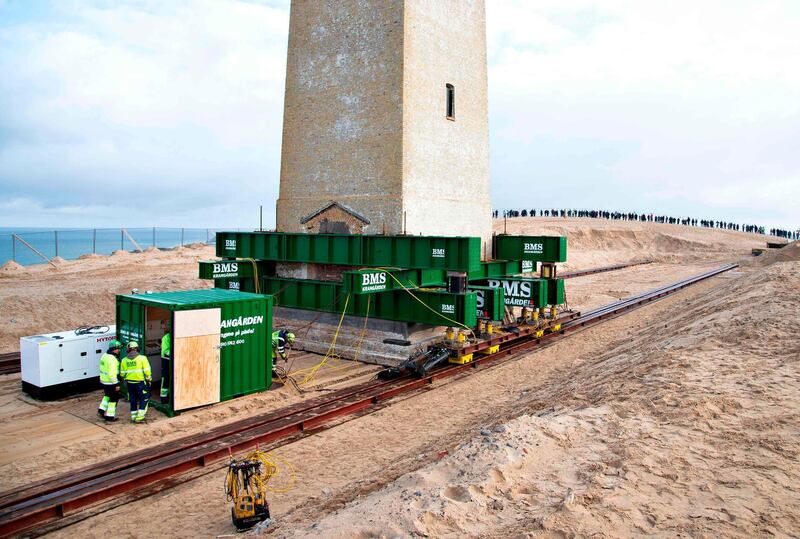 Men work on the lighthouse in Rubjerg Knude that is being moved away from the coastline between Lonstrup and Lokken, Jutland, Denmark. AFP