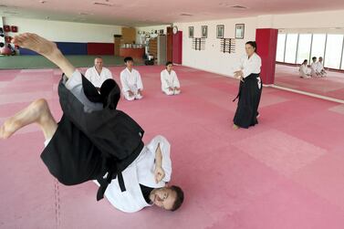 Vladimir Bojovic is thrown across the mat by Cathy Darnell at Zanshinkan Aikido club in Dubai. Chris Whiteoak / The National