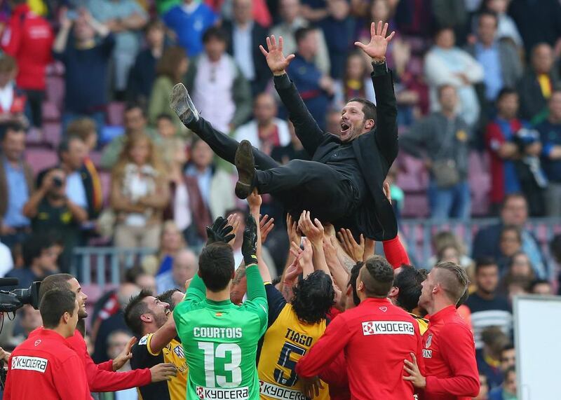 Atletico Madrid players toss coach Diego Simeone in the air after winning the Spanish Primera Liga with a 1-1 draw against Barcelona at Camp Nou on May 17, 2014, in Barcelona, Spain.  Alex Livesey / Getty Images