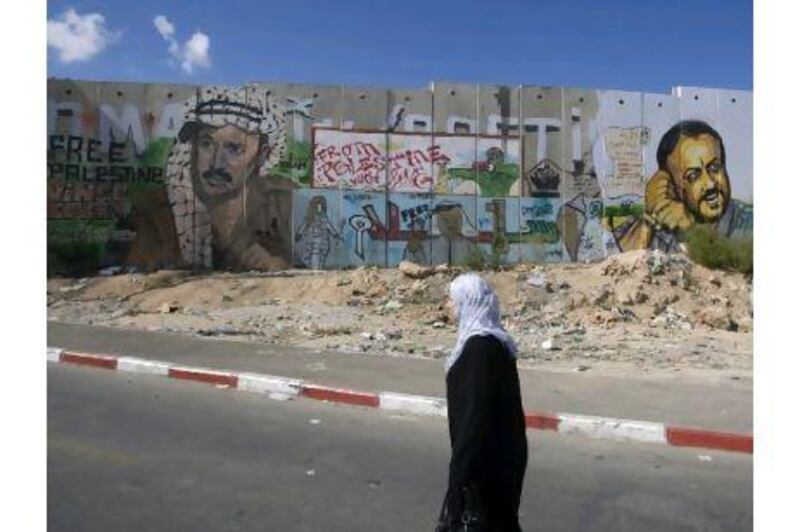 A Palestinian woman walks past a section of Israel's controversial separation barrier in the West Bank Qalandia refugee camp on the outskirts of Jerusalem.