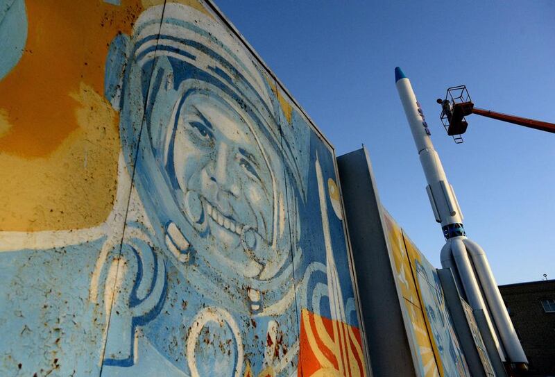 Workers renovate a model of a Proton booster rocket in front of a wall painting depicting Yuri Gagarin, the first man in space, at  the Russian-leased Baikonur Cosmodrome in Kazakhstan. Vasily Maximov / AFP Photo