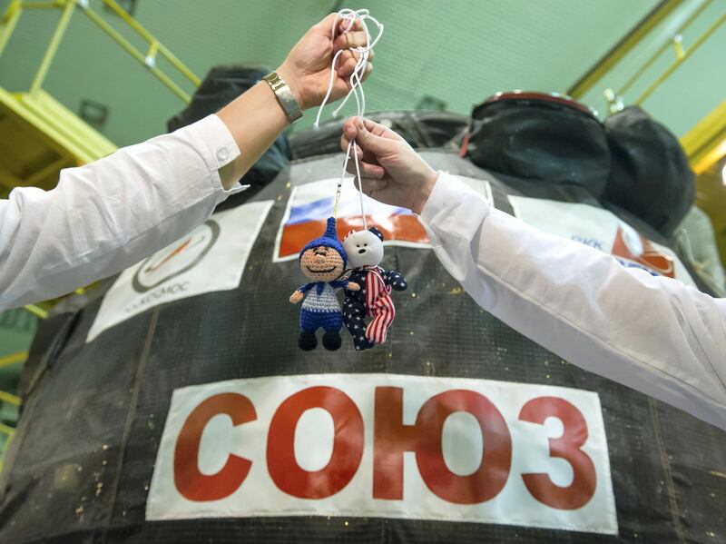 jsc2017e096664 (July 17, 2017) --- In the Integration Facility at the Baikonur Cosmodrome in Kazakhstan, unidentified Expedition 52-53 crewmembers display toys from their children July 17 outside their Soyuz MS-05 spacecraft during a fit check dress rehearsal. The toys are hung above the crewmembers’ heads in the Soyuz’ descent module compartment as weightless, or “zero-g” indicators during the launch phase of the mission. Randy Bresnik of NASA, Sergey Ryazanskiy of the Russian Federal Space Agency (Roscosmos) and Paolo Nespoli of the European Space Agency will launch July 28 on the Soyuz MS-05 spacecraft for a five-month mission on the International Space Station. Credit: Andrey Shelepin/Gagarin Cosmonaut Training Center