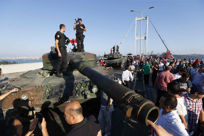 Policemen stand on a military vehicle after troops involved in the coup surrendered on the Bosphorus Bridge in Istanbul, Turkey July 16, 2016. Murad Sezer / Reuters