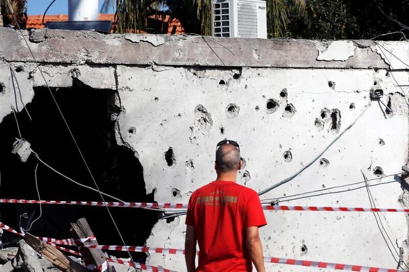 A passer-by looks at a building damaged by a rocket fired from the Gaza Strip overnight, in the Israeli city of Ashkelon. Reuters