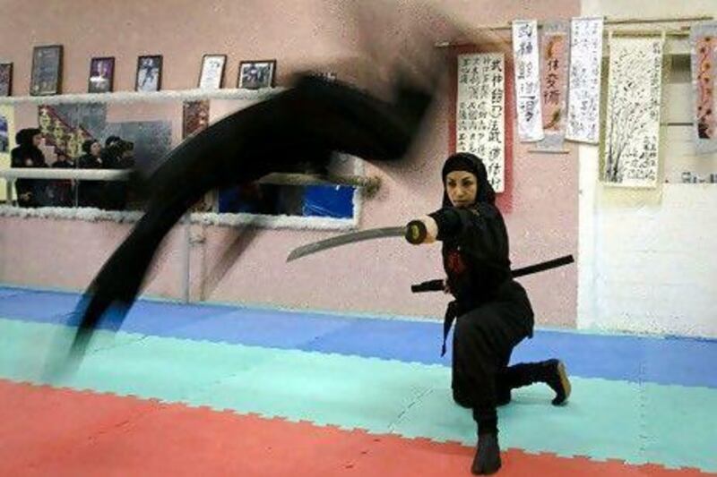 A Ninjutsu practitioner jumps over a sword as members of various Ninjutsu schools showcase their skills to the media in their gym 45 kilometres from Tehran in February.