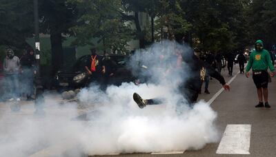 A demonstrator kicks back a tear gas canister during clashes following a protest against the inauguration of the new head of the Serbian Orthodox Church in the historic city of Cetinje in Montenegro.  AFP