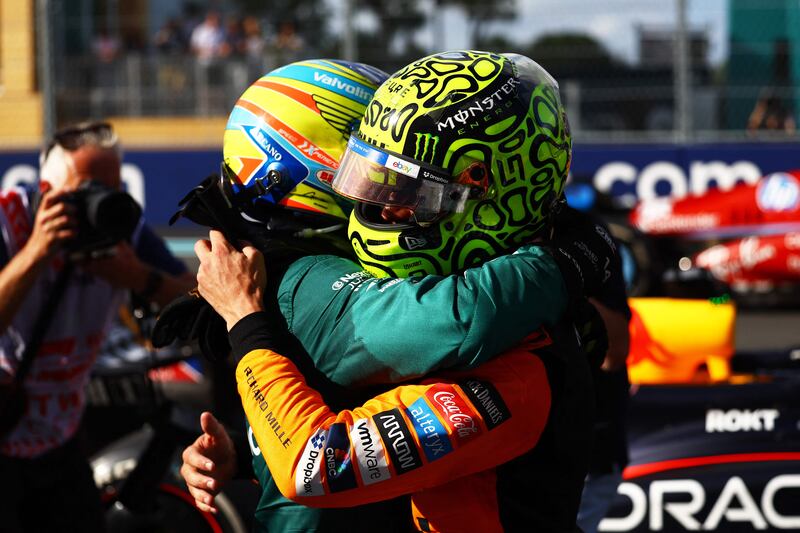 Lando Norris is congratulated by Aston Martin driver Fernando Alonso after winning his first F1 race. AFP