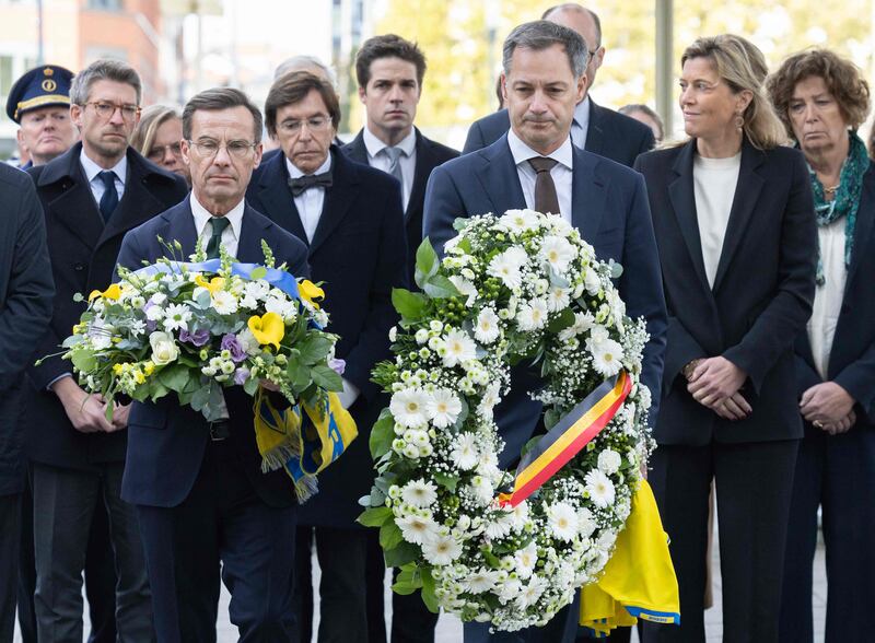 From left, Belgium Prime Minister Alexander De Croo and his Swedish counterpart Ulf Kristersson hold wreaths near the scene of a fatal shooting in Brussels. AFP