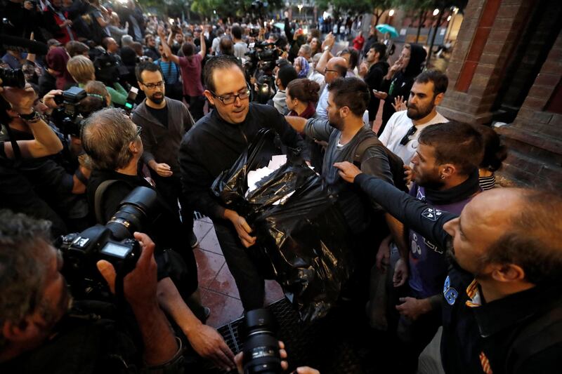 A man holds ballots at a polling station for the banned independence referendum in Barcelona, Spain. Yves Herman / Reuters