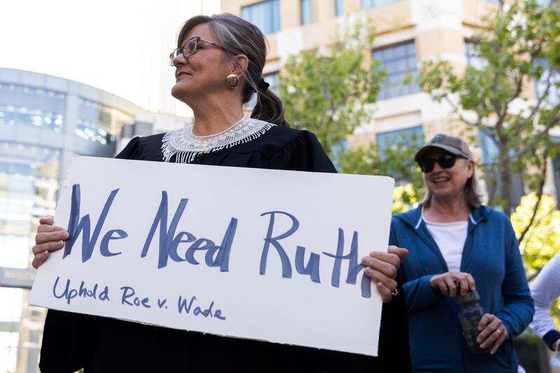 Alexandra Murphy, of Oakland, dresses as former Supreme Court Justice Ruth Bader Ginsburg while attending a protest outside the Ronald V Dellums federal building in Oakland, California.  San Francisco Chronicle / AP