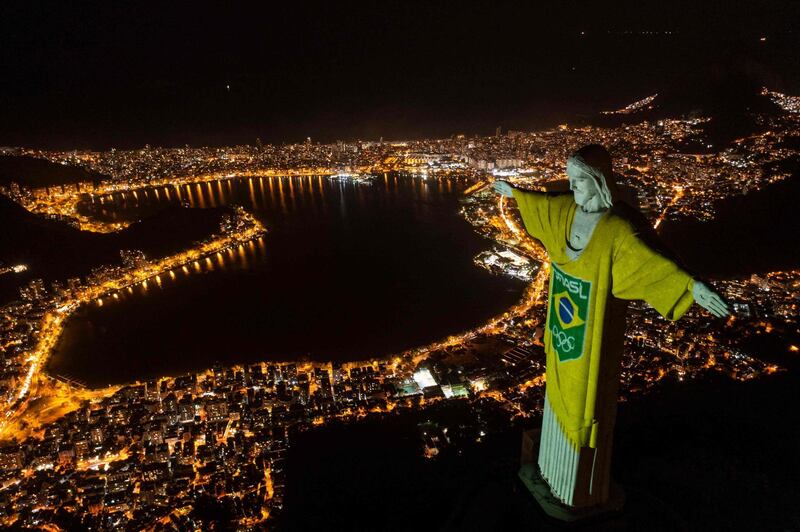 The statue of Christ the Redeemer in Rio de Janeiro, illuminated with the colours of the Brazilian flag and Olympic arrows to mark 100 days till the Tokyo Games, on Wednesday, April 14. AFP