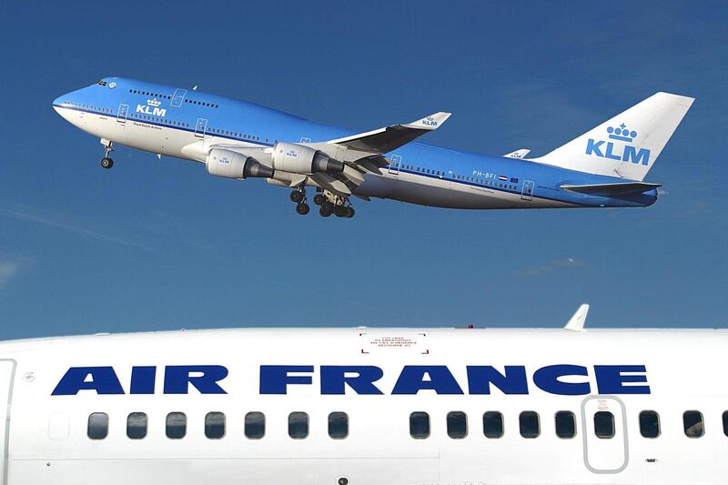 (FILES) In this file photo taken on January 01, 2003 at Schipol airport in Amsterdam shows a KLM Boeing 747-400 flying over an Air-France plane. Shares in Air France-KLM plummeted on February 27, 2019, a day after the Dutch government announced it was buying a stake in the troubled airline in a bid to match the French state's influence. / AFP / AFP FILES / -
