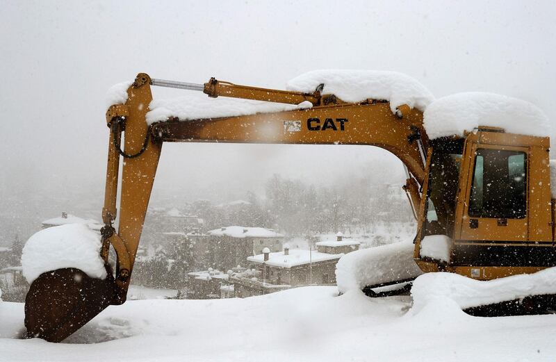 An earthmover clears snow in the town of Hasroun in Mount Lebanon. AFP