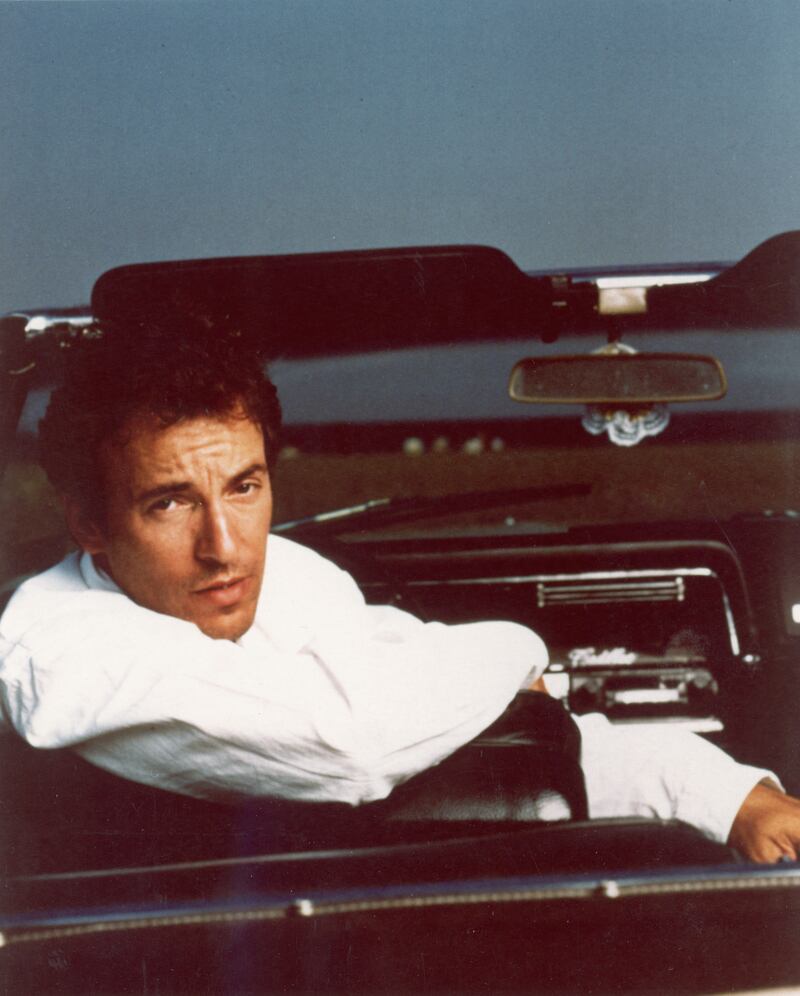 Springsteen posing in the driver's seat of a Cadillac convertible in 1987. Getty Images