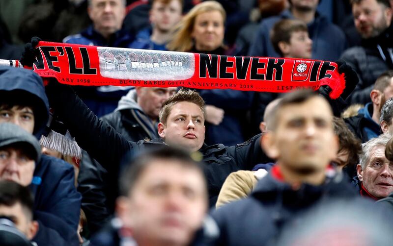 A Manchester United fan with a scarf that reads 'We’ll never die' in honour of the Busby Babes. EPA