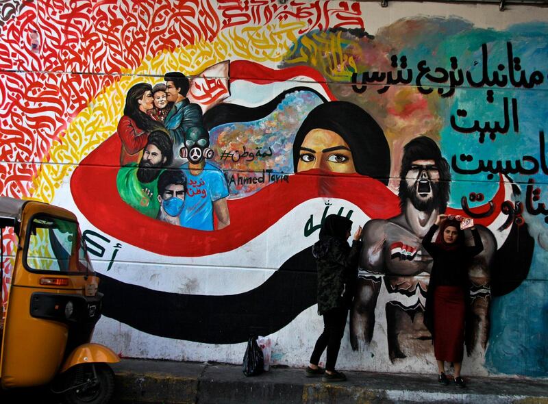 Women stand near a mural in a tunnel during ongoing anti-government protests in downtown Baghdad, Iraq. AP Photo