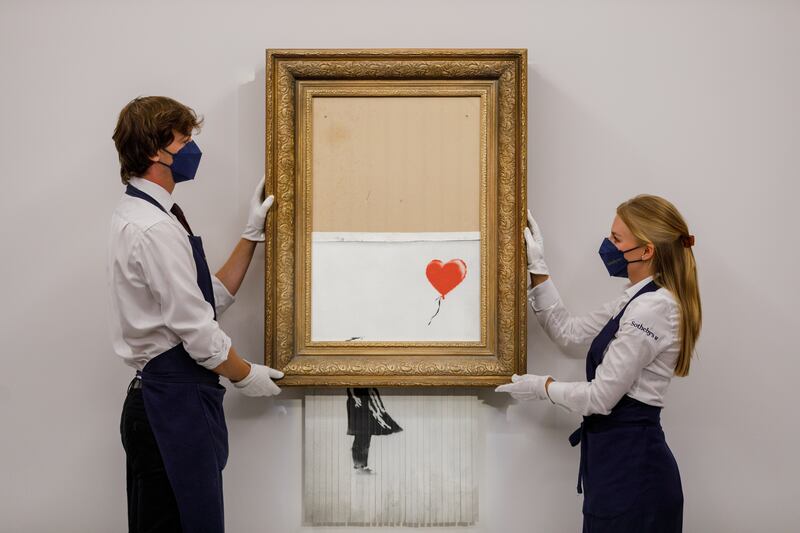 Banksy's 'Love is in the Bin' (2018) started going through a shredder during a Sotheby's auction in London in 2018. Getty Images