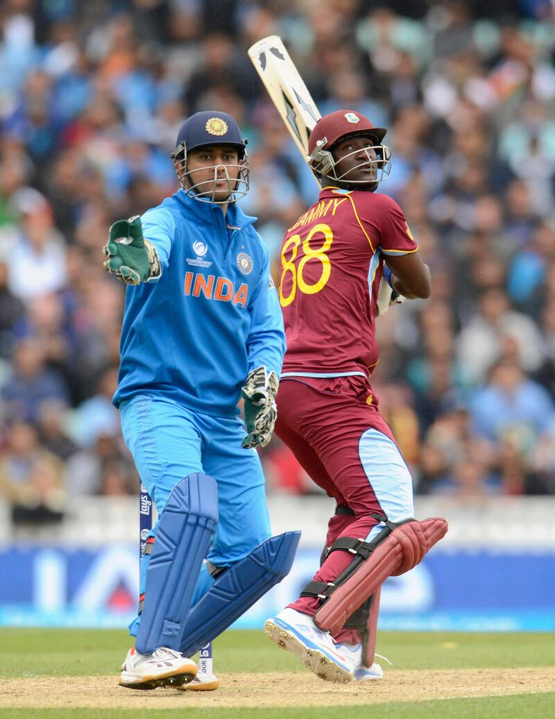 West Indies' Darren Sammy hits out as India's captain Mahendra Singh Dhoni (L) looks on during the ICC Champions Trophy group B match at The Oval cricket ground, London June 11, 2013. REUTERS/Philip Brown (BRITAIN - Tags: SPORT CRICKET) *** Local Caption ***  PB12_CRICKET-CHAMPI_0611_11.JPG