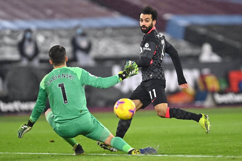 Liverpool's Egyptian midfielder Mohamed Salah (R) shoots past West Ham United's Polish goalkeeper Lukasz Fabianski (L) to score their second goal during the English Premier League football match between West Ham United and Liverpool at The London Stadium, in east London on January 31, 2021. (Photo by Justin Setterfield / POOL / AFP) / RESTRICTED TO EDITORIAL USE. No use with unauthorized audio, video, data, fixture lists, club/league logos or 'live' services. Online in-match use limited to 120 images. An additional 40 images may be used in extra time. No video emulation. Social media in-match use limited to 120 images. An additional 40 images may be used in extra time. No use in betting publications, games or single club/league/player publications. / 